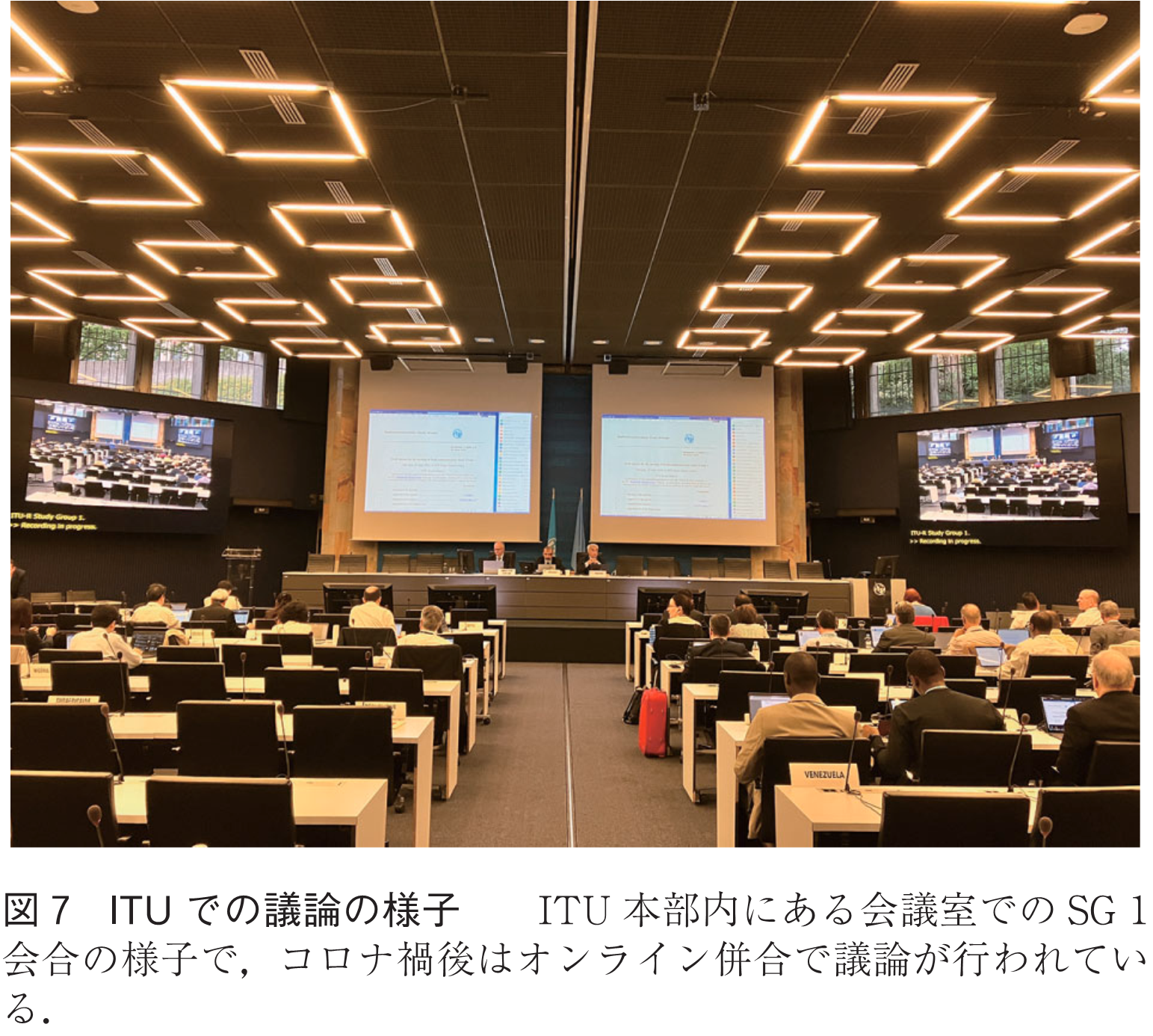 図7　ITUでの議論の様子　　ITU本部内にある会議室でのSG 1会合の様子で，コロナ禍後はオンライン併合で議論が行われている．